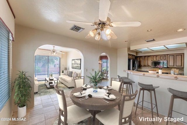 dining space with ceiling fan and a textured ceiling