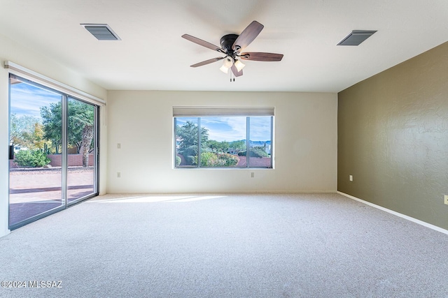 carpeted empty room with ceiling fan and a healthy amount of sunlight