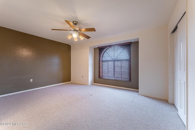 carpeted empty room featuring ceiling fan