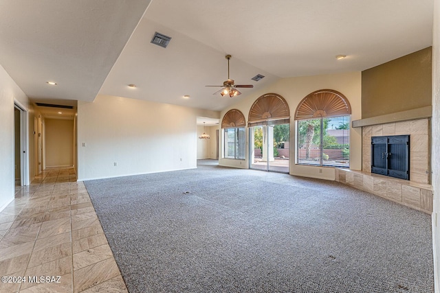 unfurnished living room with ceiling fan, lofted ceiling, a fireplace, and light carpet