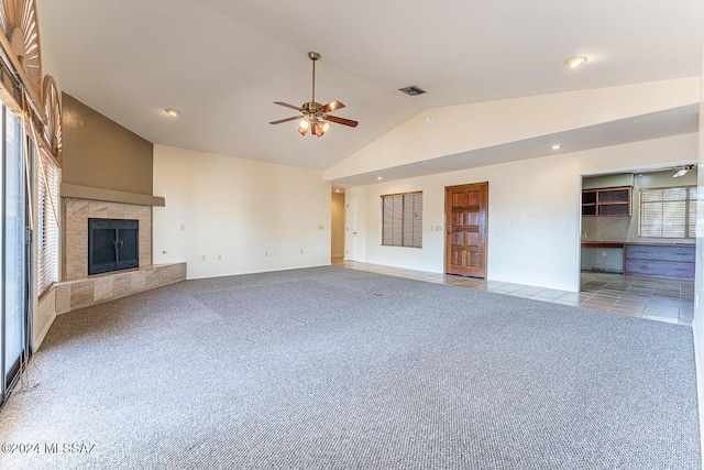 unfurnished living room featuring light carpet, a tile fireplace, ceiling fan, and lofted ceiling