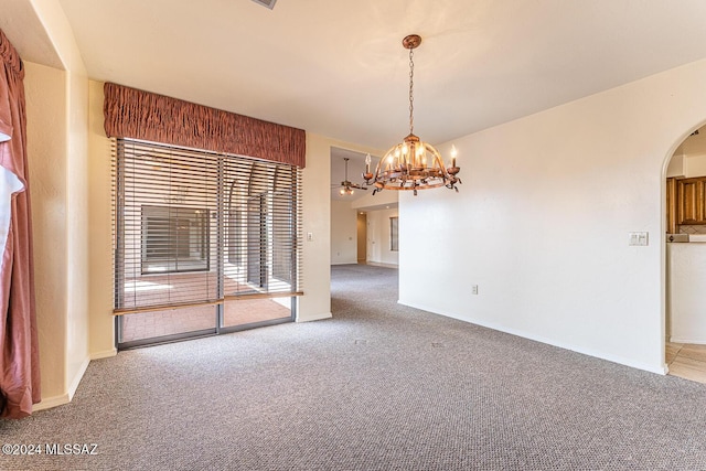 carpeted spare room featuring a notable chandelier