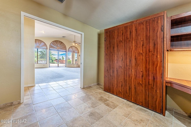 carpeted spare room with ceiling fan and vaulted ceiling