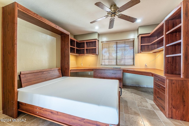 unfurnished bedroom featuring built in desk and ceiling fan