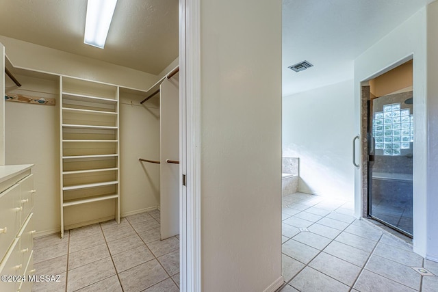 spacious closet featuring light tile patterned floors