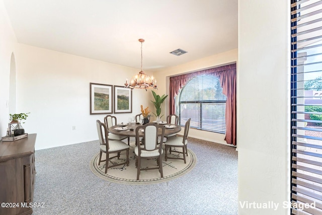 dining area featuring carpet floors and an inviting chandelier