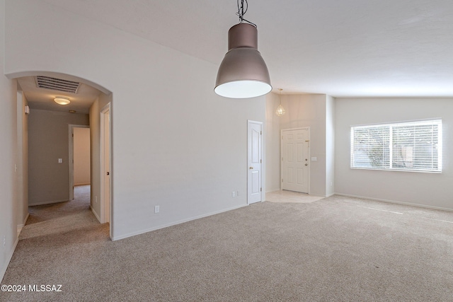 carpeted empty room featuring vaulted ceiling