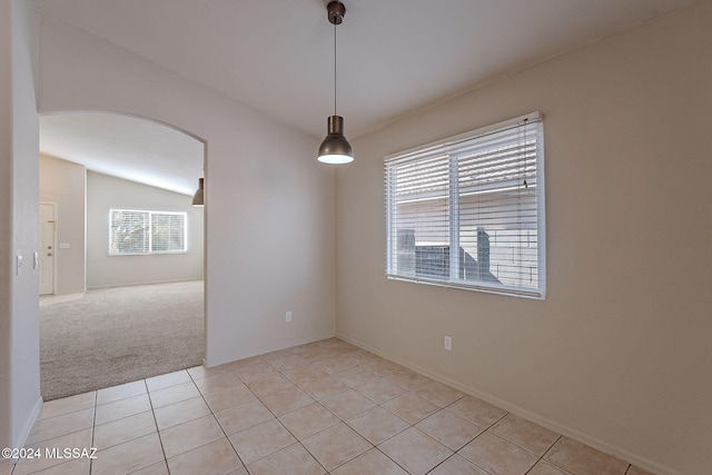 unfurnished room featuring light tile patterned floors, lofted ceiling, and a healthy amount of sunlight