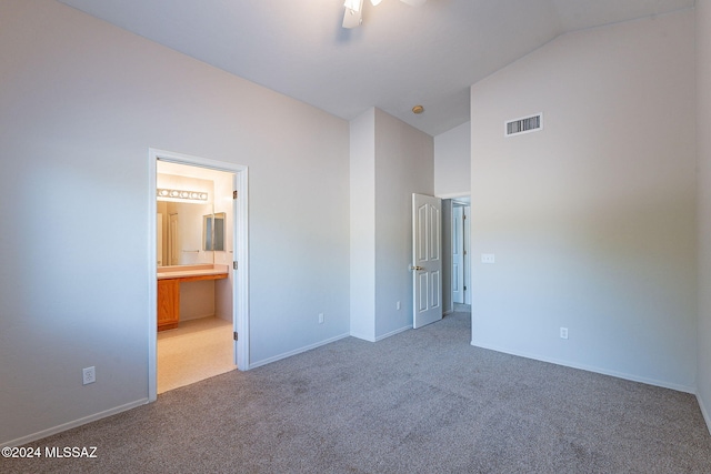 unfurnished bedroom with high vaulted ceiling, light colored carpet, ensuite bath, and ceiling fan