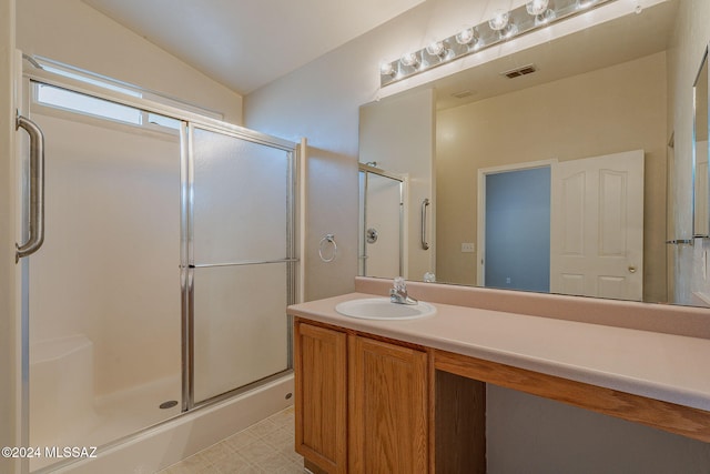 bathroom featuring vanity, walk in shower, and vaulted ceiling