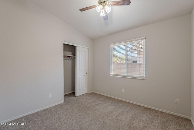 unfurnished bedroom with ceiling fan, a closet, light colored carpet, and lofted ceiling