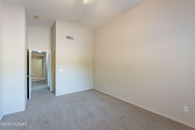 empty room featuring light carpet and vaulted ceiling