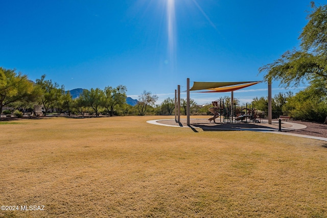 surrounding community featuring a mountain view, a yard, and a playground