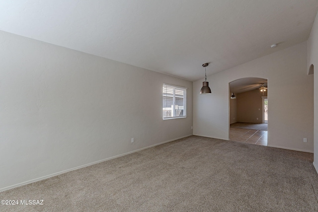 spare room with light colored carpet, vaulted ceiling, and ceiling fan