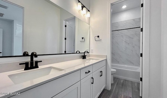 full bath with double vanity, toilet, visible vents, and a sink