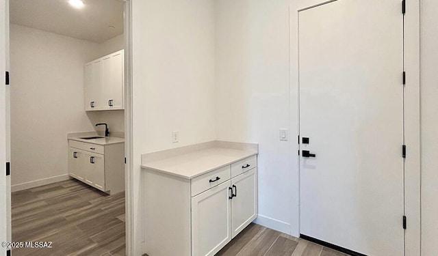 interior space with a sink, baseboards, and light wood-style floors
