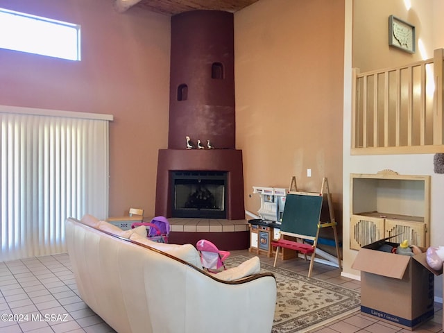 tiled living room featuring a towering ceiling and a fireplace