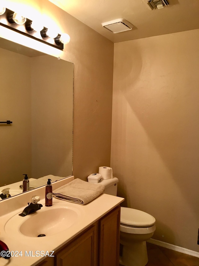 bathroom featuring tile patterned flooring, vanity, and toilet