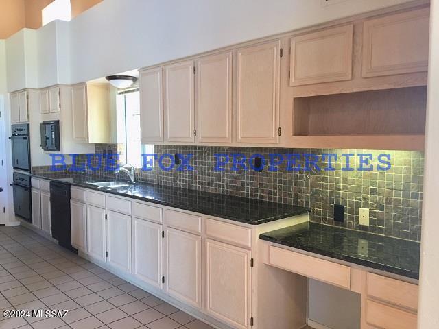 kitchen featuring light tile patterned floors, sink, backsplash, and black appliances