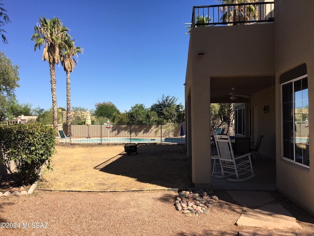 view of yard with a fenced in pool and ceiling fan