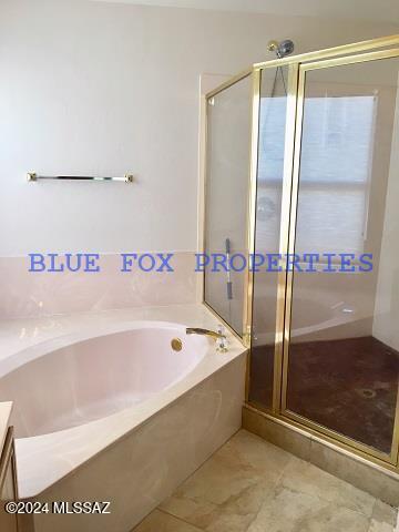 bathroom featuring tile patterned flooring, vanity, and shower with separate bathtub