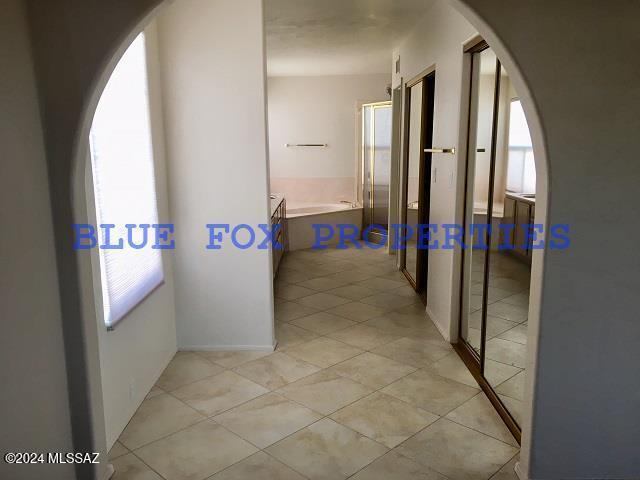 hallway with plenty of natural light and light tile patterned flooring