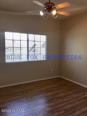 unfurnished room featuring ceiling fan and dark wood-type flooring