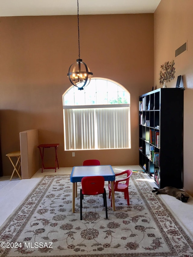 dining area with a towering ceiling and a notable chandelier