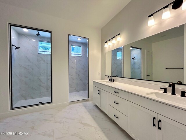 bathroom featuring a sink, a marble finish shower, marble finish floor, and double vanity