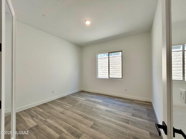 empty room featuring baseboards and wood finished floors