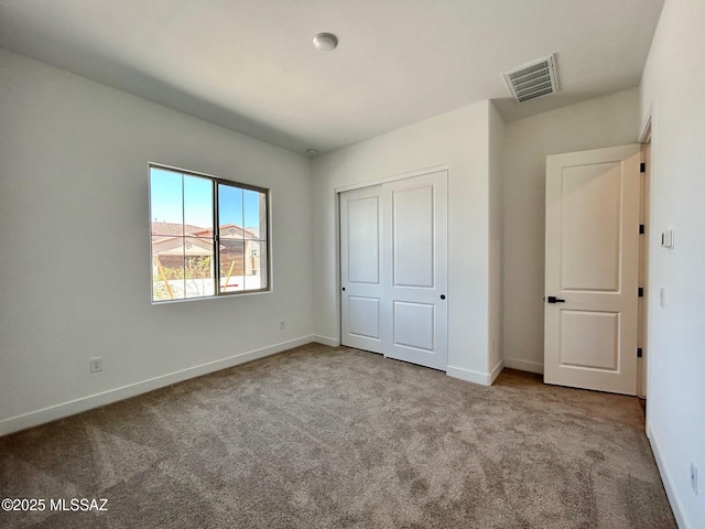 unfurnished bedroom featuring a closet, baseboards, carpet, and visible vents