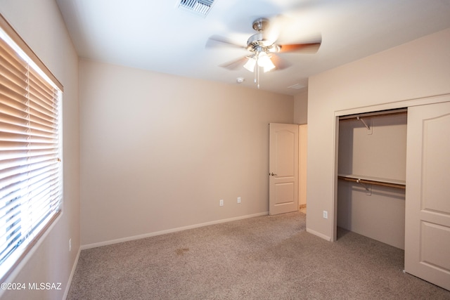 unfurnished bedroom with ceiling fan, a closet, and light carpet