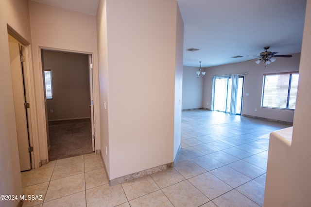 hall featuring light tile patterned floors and an inviting chandelier