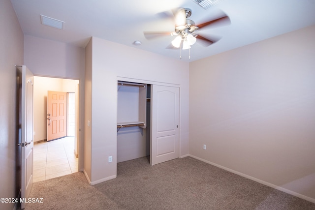 unfurnished bedroom featuring ceiling fan, a closet, and light carpet