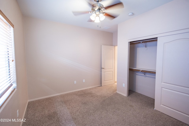 unfurnished bedroom with ceiling fan, light colored carpet, and a closet