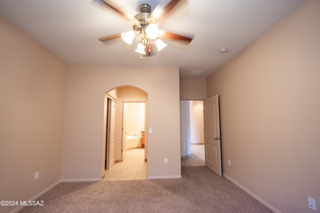 unfurnished bedroom featuring ensuite bathroom, ceiling fan, and light carpet