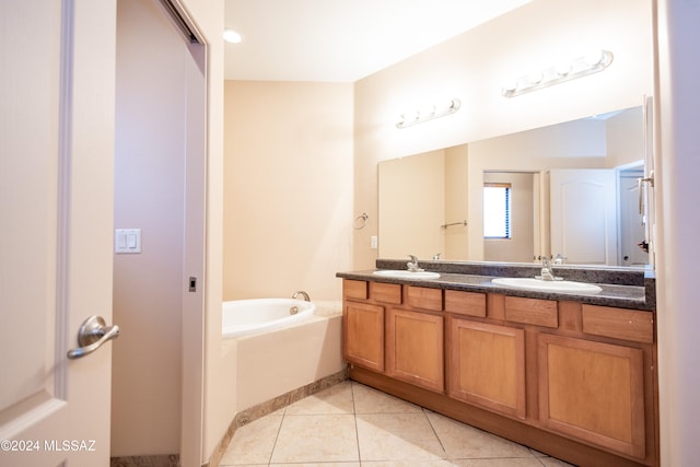 bathroom featuring tile patterned flooring, vanity, and a bathing tub