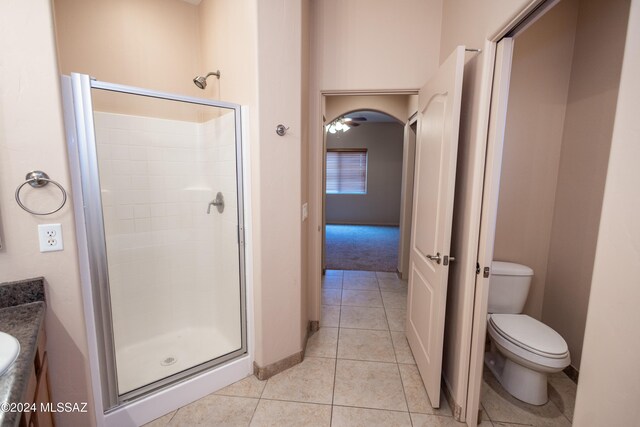 bathroom featuring vanity, tile patterned flooring, ceiling fan, toilet, and a shower with shower door