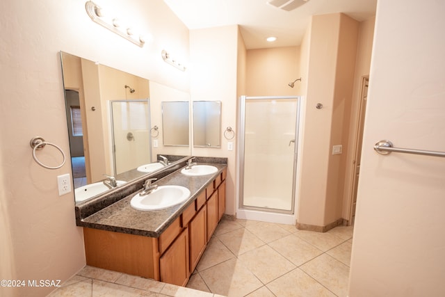 bathroom featuring tile patterned flooring, vanity, and a shower with shower door