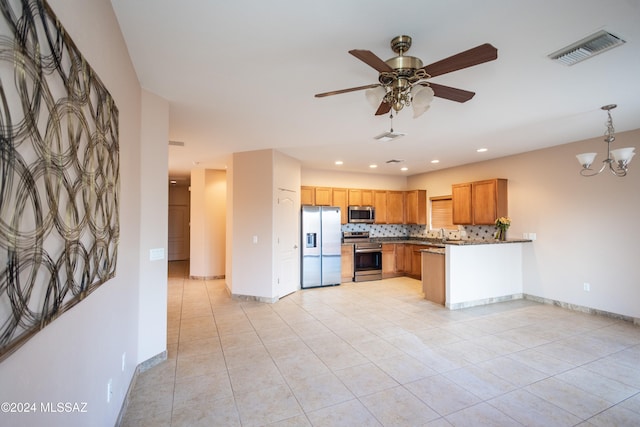 kitchen featuring stainless steel appliances, backsplash, kitchen peninsula, light tile patterned floors, and ceiling fan with notable chandelier