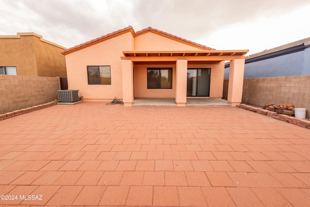 back of house with central AC unit and a patio