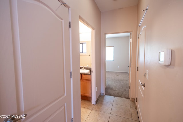 hallway with light tile patterned floors and sink