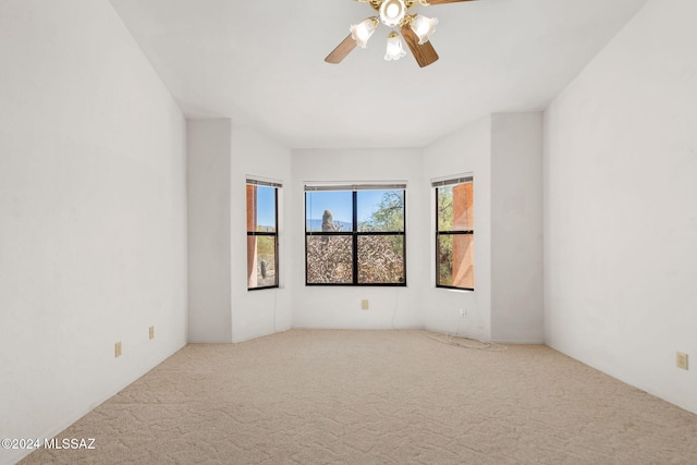 carpeted spare room with ceiling fan