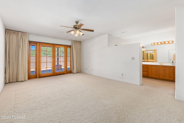 carpeted spare room featuring french doors and ceiling fan