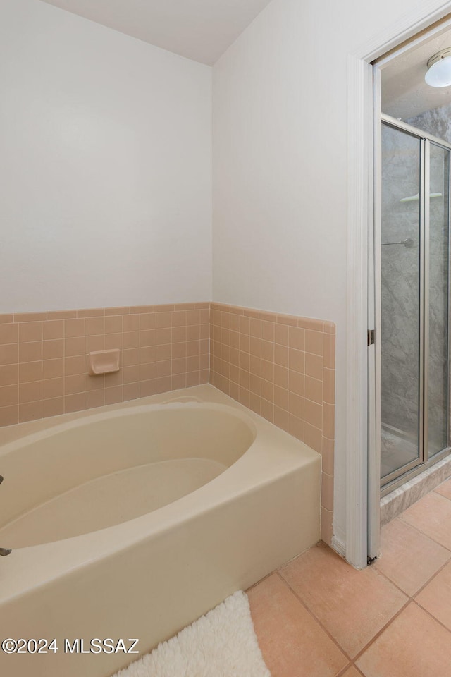 bathroom featuring tile patterned flooring and shower with separate bathtub