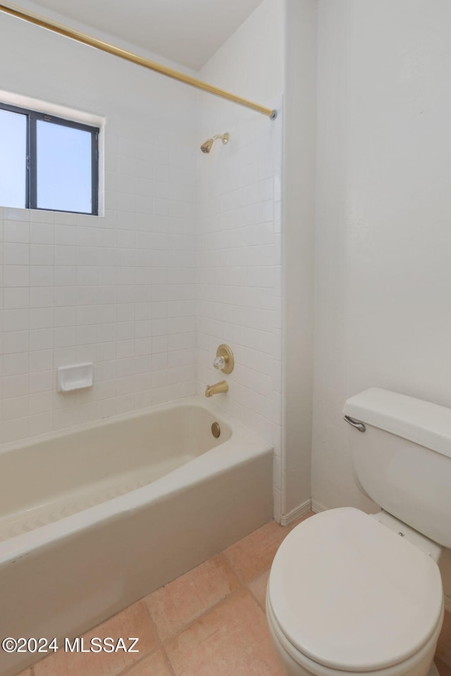 bathroom with tile patterned flooring, toilet, and tiled shower / bath