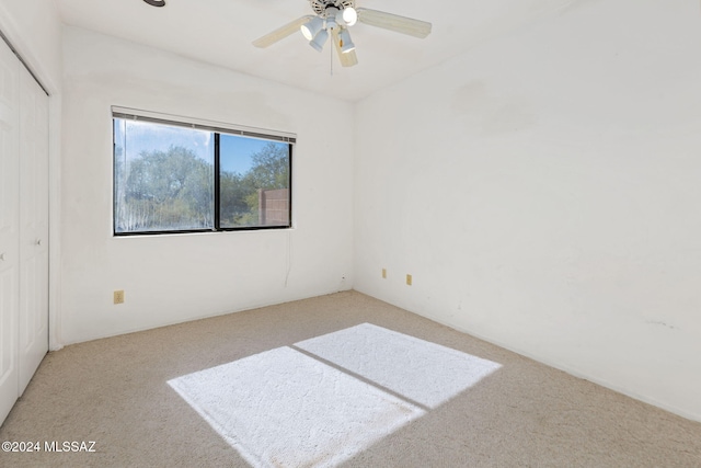 carpeted empty room featuring ceiling fan