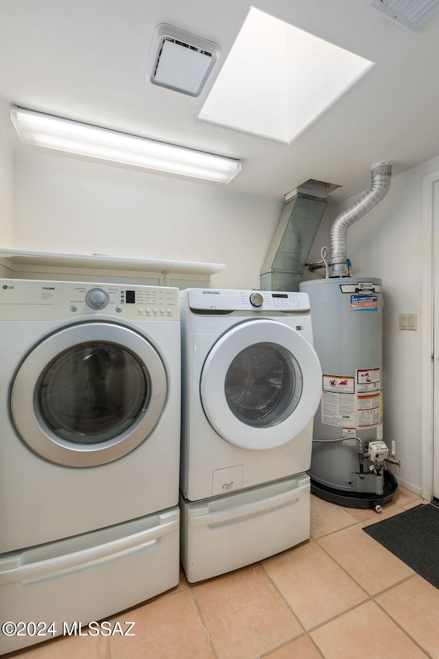 washroom featuring water heater, light tile patterned floors, and independent washer and dryer