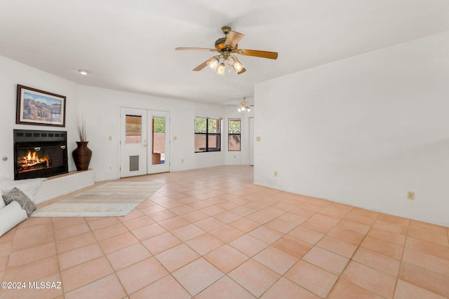 unfurnished living room with ceiling fan and light tile patterned flooring