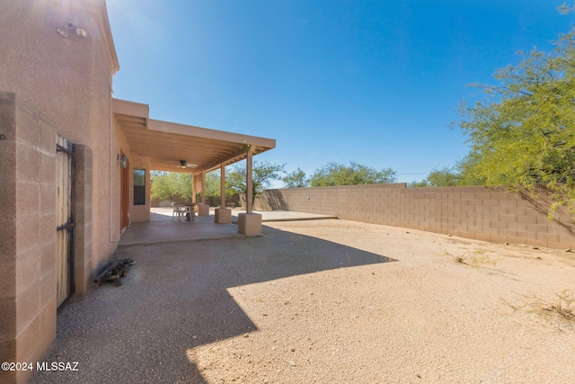 view of yard featuring ceiling fan and a patio area